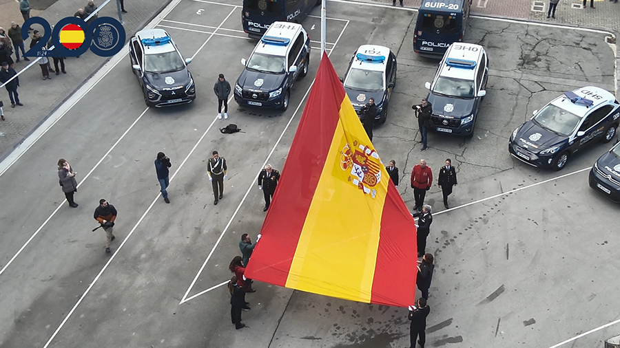 Agentes de la Policía Nacional izando la Bandera de España.